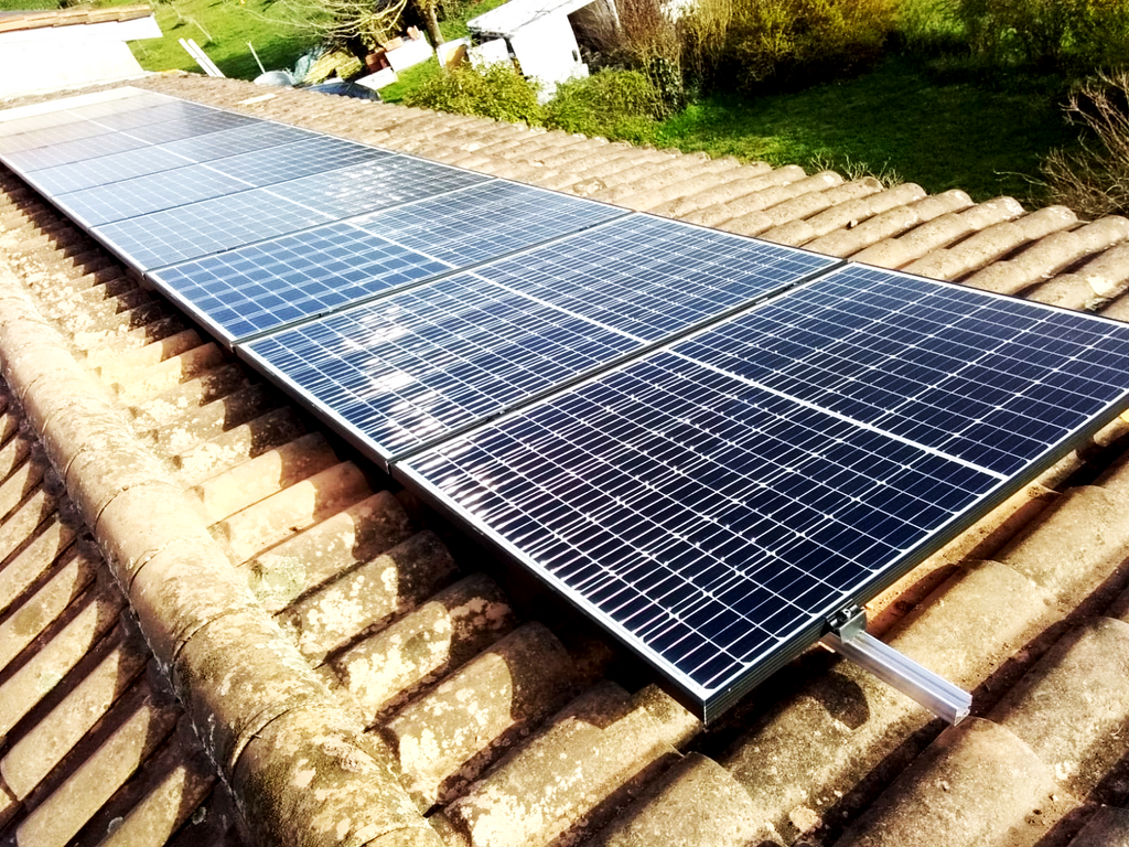 Installation de panneaux solaires sur une toiture en tuiles.