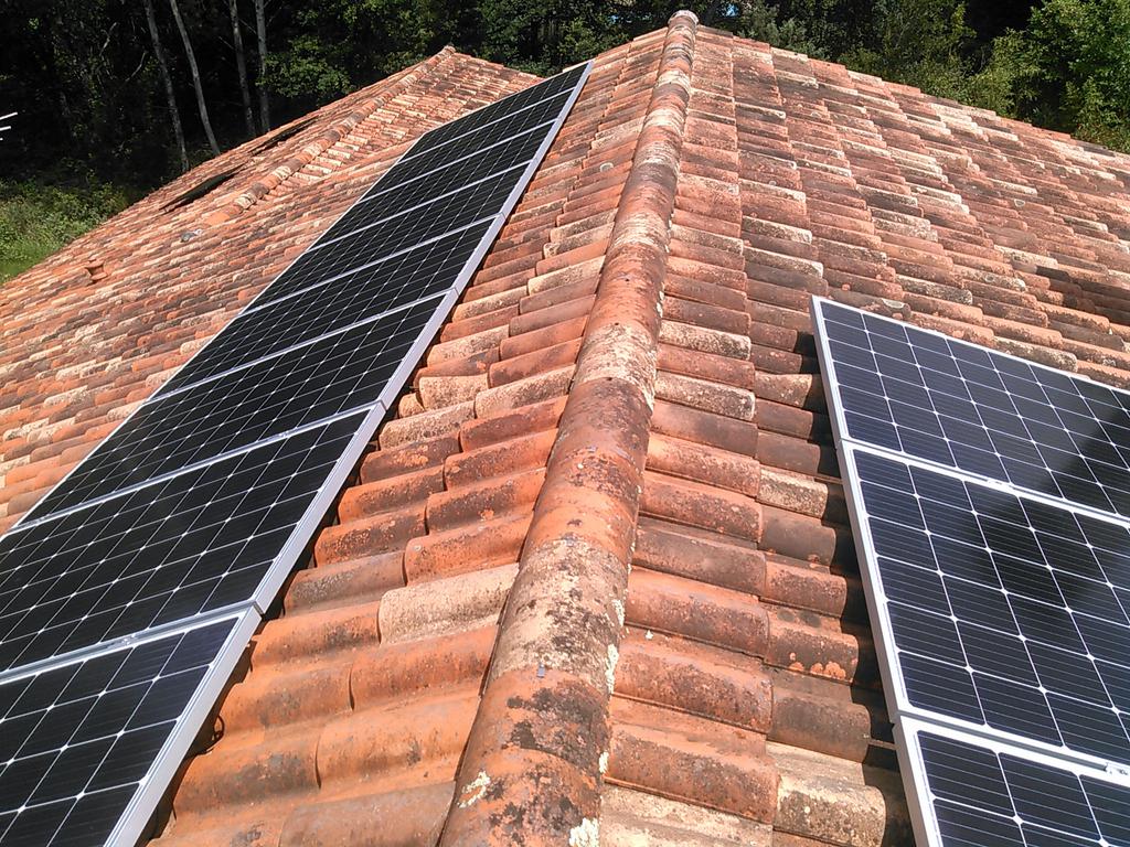 Installation de panneaux solaires sur une toiture en tuiles.
